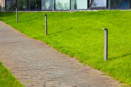urban landscaping aesthetic pavement track along lawn grass plot local city scape place street tileの写真素材