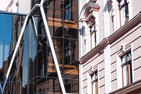 old vs new architecture contrast border modern and historical buildings facade glass wall exterior arch windows high skyscraper background city scape conceptの写真素材