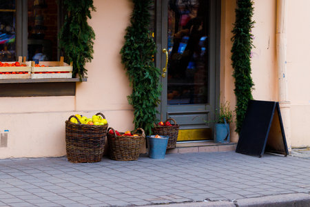 pavement side walk counter fruits vegetables retail place along street local city scape scene shop entrance exterior facade ordinary urban viewの写真素材