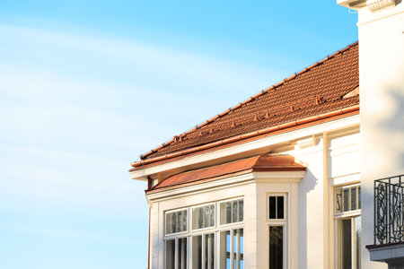 village cottage exterior facade external wall corner shape window balcony and roof tile building frame pattern panorama front side view with clear sky background empty spaceの写真素材