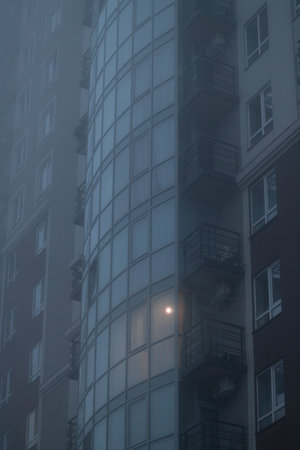 atmospheric city multi apartment building in twilight smoke blue toning urban local close up view scene vertical formatの写真素材