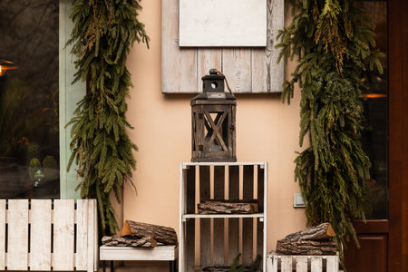 low light decorative elements wooden box and bench with vintage lantern and pine branchesの写真素材