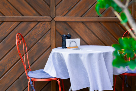 patio cafe empty furniture chairs and table with white sheet without peopleの写真素材
