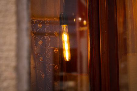 warm light stick lamp decorative hanging object inside dusk room window view background conceptの写真素材