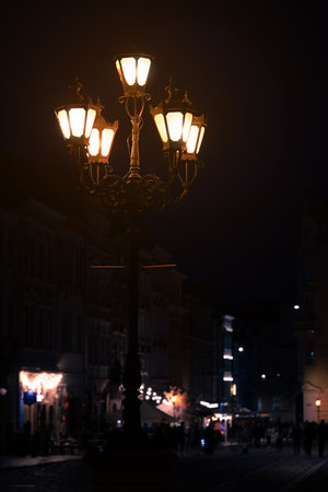 vertical long exposure lantern night city square light foreground and walking people's silhouettes background fuzzy motionの写真素材