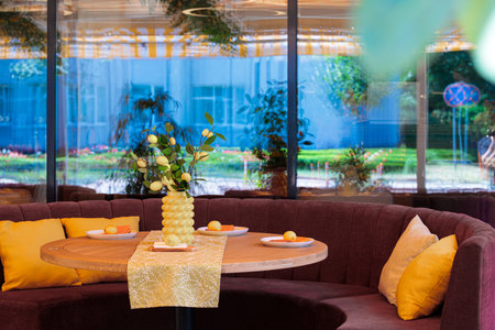 cafe space interior balcony space comfortable furniture table and sofa with pillow vivid colors yellow and blue windows background viewの写真素材