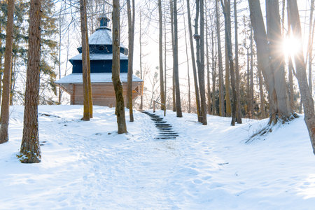 rustic country side snowy woods with wooden church north European region landscape sun light bright dayの写真素材