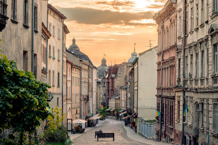 historical street city scape Eastern Europe region in Ukraine Lviv independent country majestic old town center architecture empty from people pavement cobble stone tile in sunset evening lightの写真素材