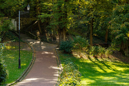 spring bright day seasonal nature scenic view landscaped park paved track and green grass lawn hills...