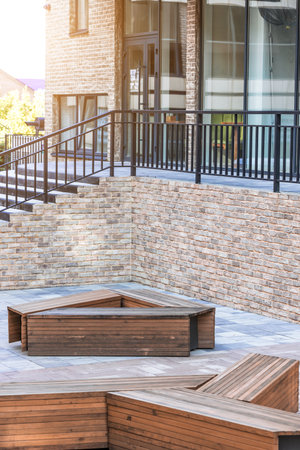 narrow street paved floor tile wooden benches design urban style landmark environment space sunny weather morningの写真素材