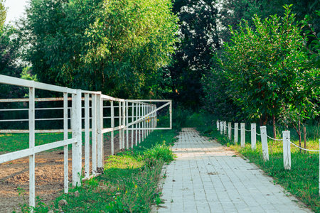 country side land ranch greenery environment space with fenced agricultural fields paved track foot path and trees private territoryの写真素材