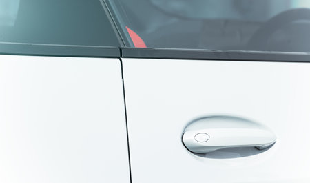 car handle door lock closed frame white metallic smooth background with glass close up vehicle view in salon for retailの写真素材