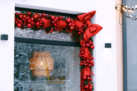 red ribbon and balls winter holiday season decoration outside elements Christmas eve season time window frame background of wall building white colorの写真素材