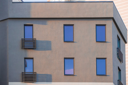 concrete block building frame facade gray cement and windows decorative balconies small ordinary...