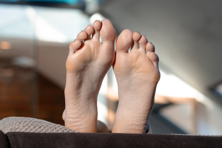female feet soles body part white skin of legs close up view indoor in studio room with blurred background apartments intimate conceptの写真素材