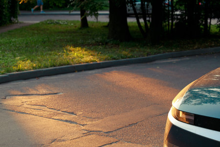car hood and head light part metallic frame on country side road with asphalt and trees side way backgroundの写真素材