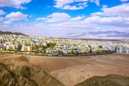 Panoramic view of a modern city nestled between arid desert mountains