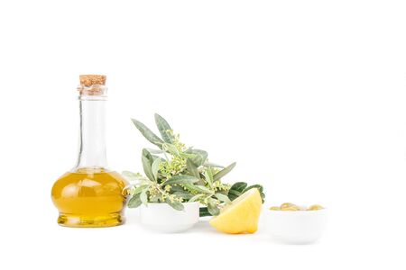 Glass bottle of premium virgin olive oil, lemon and some olives with olive branch isolated on a white background.の写真素材