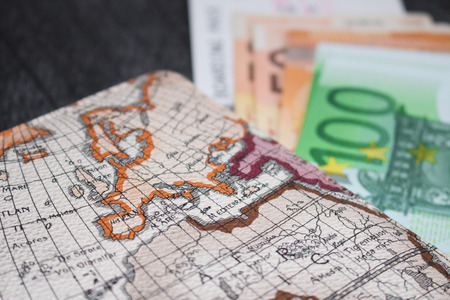 Money, Airplane ticket and map. Eurobanknotes with boarding pass and map, on black wooden background. Business and travel planning concept.の写真素材