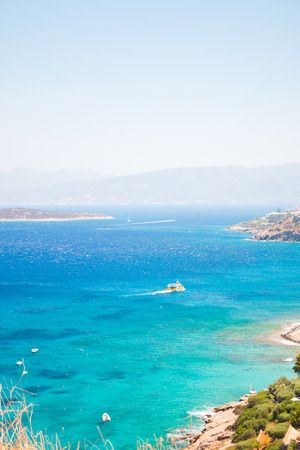 Agii Pantes Agios Nikolaos,Crete, Greece. Small uninhabited island near to Agios Nikolaos and Elounda. Blue sea and boat at summer.の写真素材