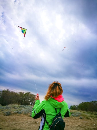 Young woman playing with colorful kite. Woman flies a kite in Greece.の写真素材