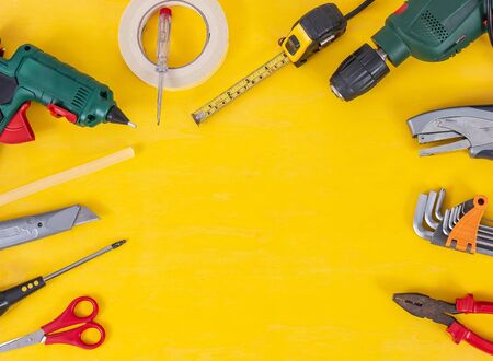 DIY Do it yourself tools on yellow background. DIY tools with copy space for text on yellow wooden...