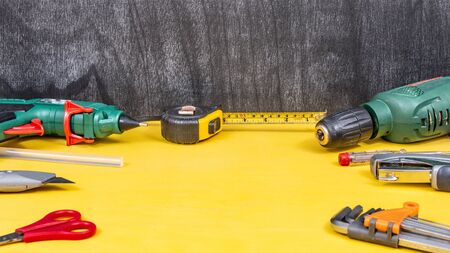 Do it yourself tools on yellow background. DIY tools with copy space for text on yellow wooden...