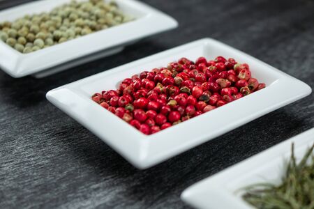 Red pepper or Pink pepper. Colorful spices in white bowls Seasonings for cooking. Natural Herbs & Spices.の写真素材