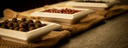 Bowl full of spices on burlap and a dark wooden background. Natural spices, vintage old seasoning...
