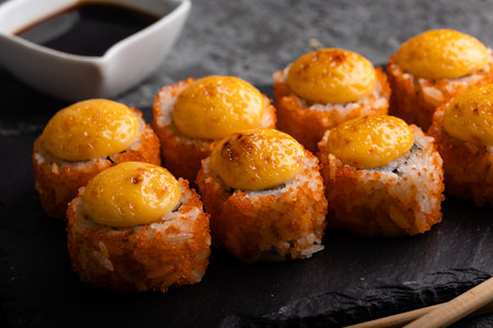 Fresh sushi roll set. Sushi rolls california with cheese. Sushi on black background, chopsticks, wasabi, soy. top view.の写真素材