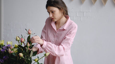 Professional florist arranging roses in flower shopの写真素材