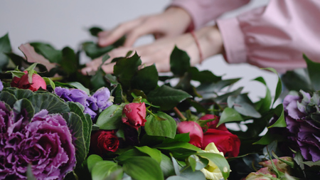 Florist puts beautiful roses for the arrangement of a modern bouquetの写真素材