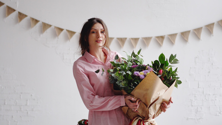 Portrait of florist with big modern bouquet of different flowersの写真素材