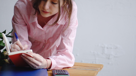 Close up view: florist writes a note on a wooden tableの写真素材