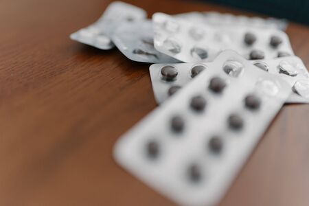 Packs of medicines on a wooden table. Natural pills and cold medicines