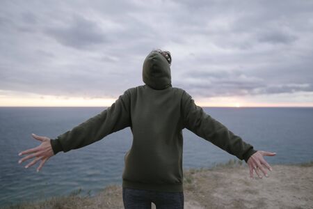 Healthy lifestyle. A beautiful caucasian woman in a sweatshirt and leggings stands on the edge of a...