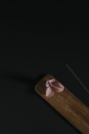 Incense on a wooden stand against a dark background. Items for aromatherapy, meditation and massageの写真素材