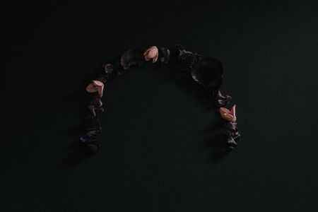 An arch of dry flowers on a black background. Aromatherapy and the concept of zen. Copyspace for...