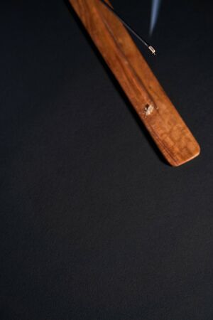 Meditation and relaxation. Item for yoga classes. Dark background, aroma wand top view, copyspace...
