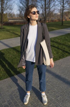 An attractive woman with a cotton bag in a suit at sunset. The concept of a healthy lifestyle...
