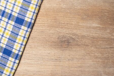 A beautiful blue-yellow tablecloth on a wooden table, a place for your text. Wooden background.の写真素材