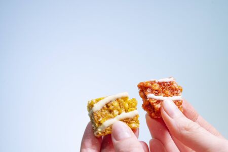 Two halves of a useful batnik in a woman's hands on a light background. Healthy eating in the office.の写真素材