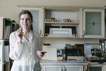Positive conversation of a woman in the office on the phone. Portrait of a small business owner while workingの写真素材