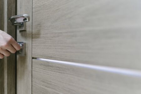 The woman closes the lock of the door with a key, a close-up. Home protection and safety.の写真素材