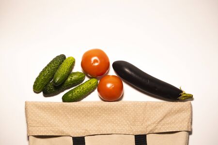 Vegetables in the cotton bag on a white background, isolate. Using eco things instead of plastic, the concept of environmental care and a minimum of wasteの写真素材