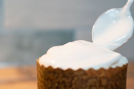 Decoration of white easter cake glaze, close-up in the kitchen, at home. Celebrating the spring...