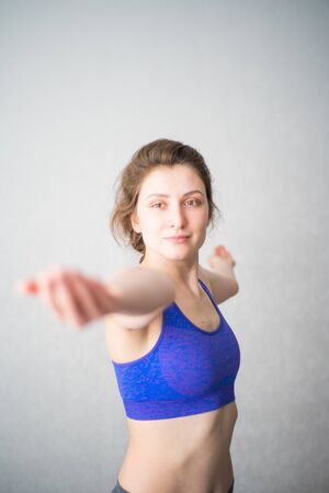 Young female yogi is concentrated in pose. Looking at the hand while performing an asana. Self-isolated at homeの写真素材