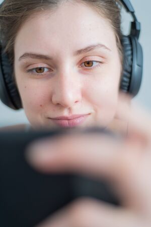 Girl gamer close-up. Woman in game headphones plays console, focus on eyes