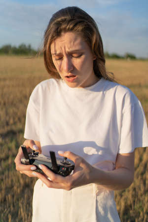 Drone control. Female pilot tries to control quadcopter in flightの写真素材