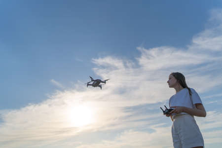 A woman learns to control a drone. Training to fly on a quadcopter in a safe place